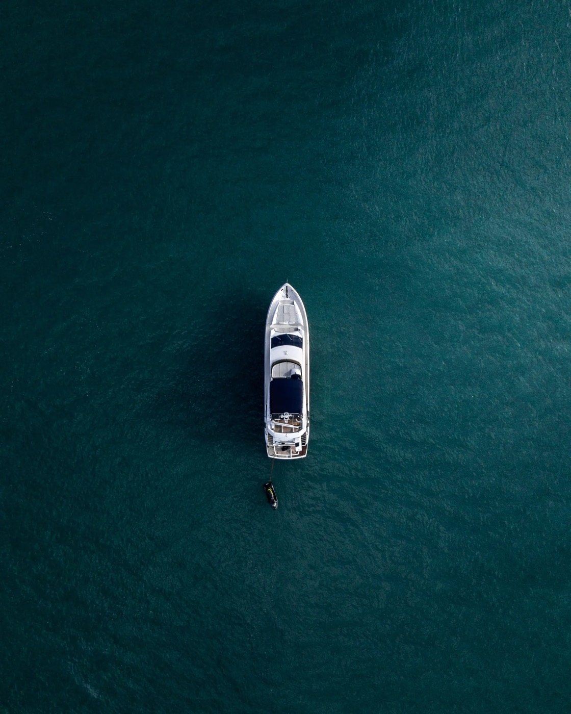 Aerial view of a boat cutting across dark water